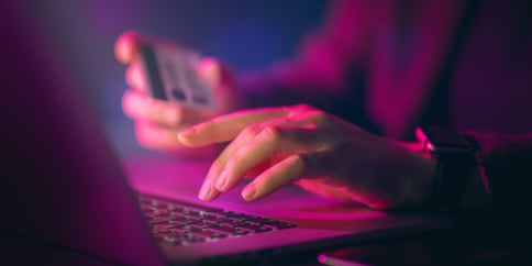 Woman inputting banking card details to make an online payment.