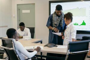This is an image of three mean and one woman working in a boardroom.