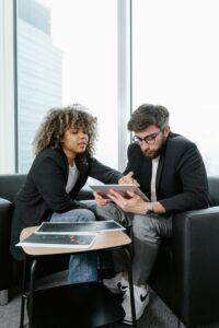 This is an image of a man and woman sitting together looking at an ipad.