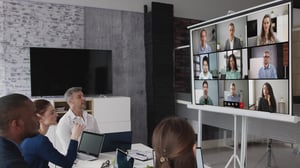 This is an image of people in a boardroom on a conference call.