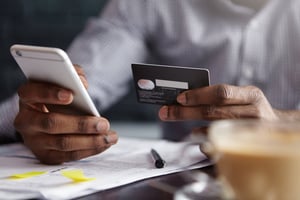 This is an image of a man making a payment over the phone with his credit card