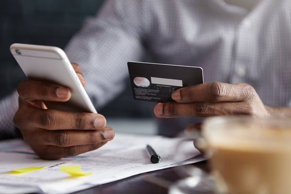This is an image of a man making a payment over the phone with his credit card