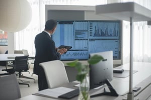 This is an image of a man analysing data on a large screen 