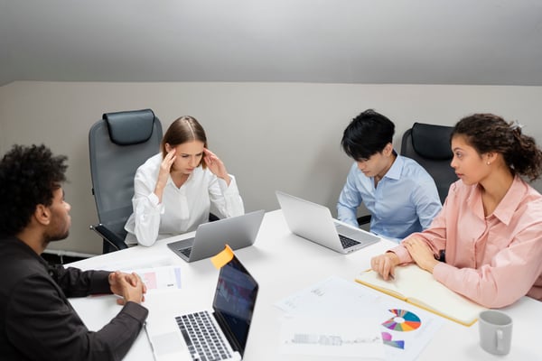 This is an image of people working at a boardroom desk. 