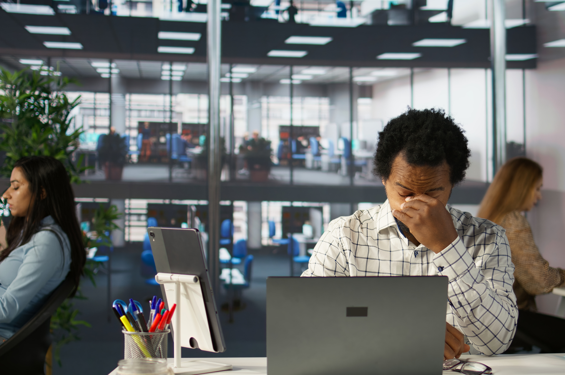 This is an image of a frutrated employee sitting at a desk in an office