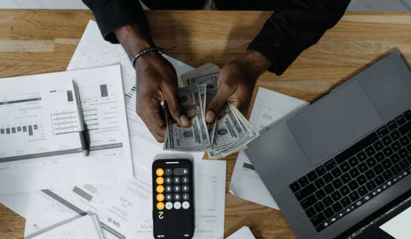 This is an image of a man counting money at his desk.