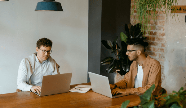 This is an image of two men working at a desk.
