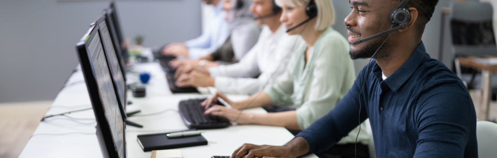 People working in a call centre sitting at their desks with headsets