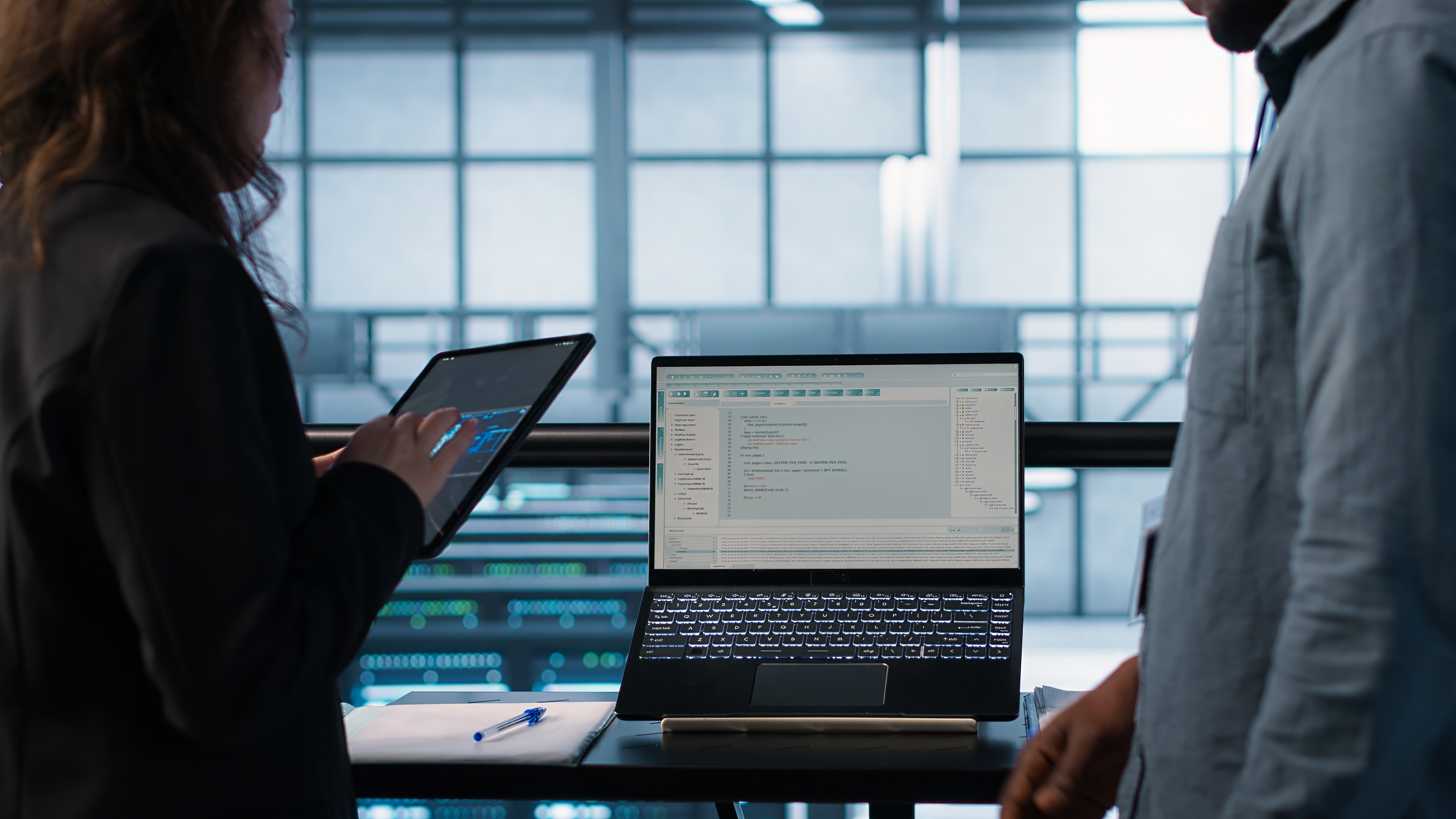 This is an image of two people looking at data on a laptop and tablet
