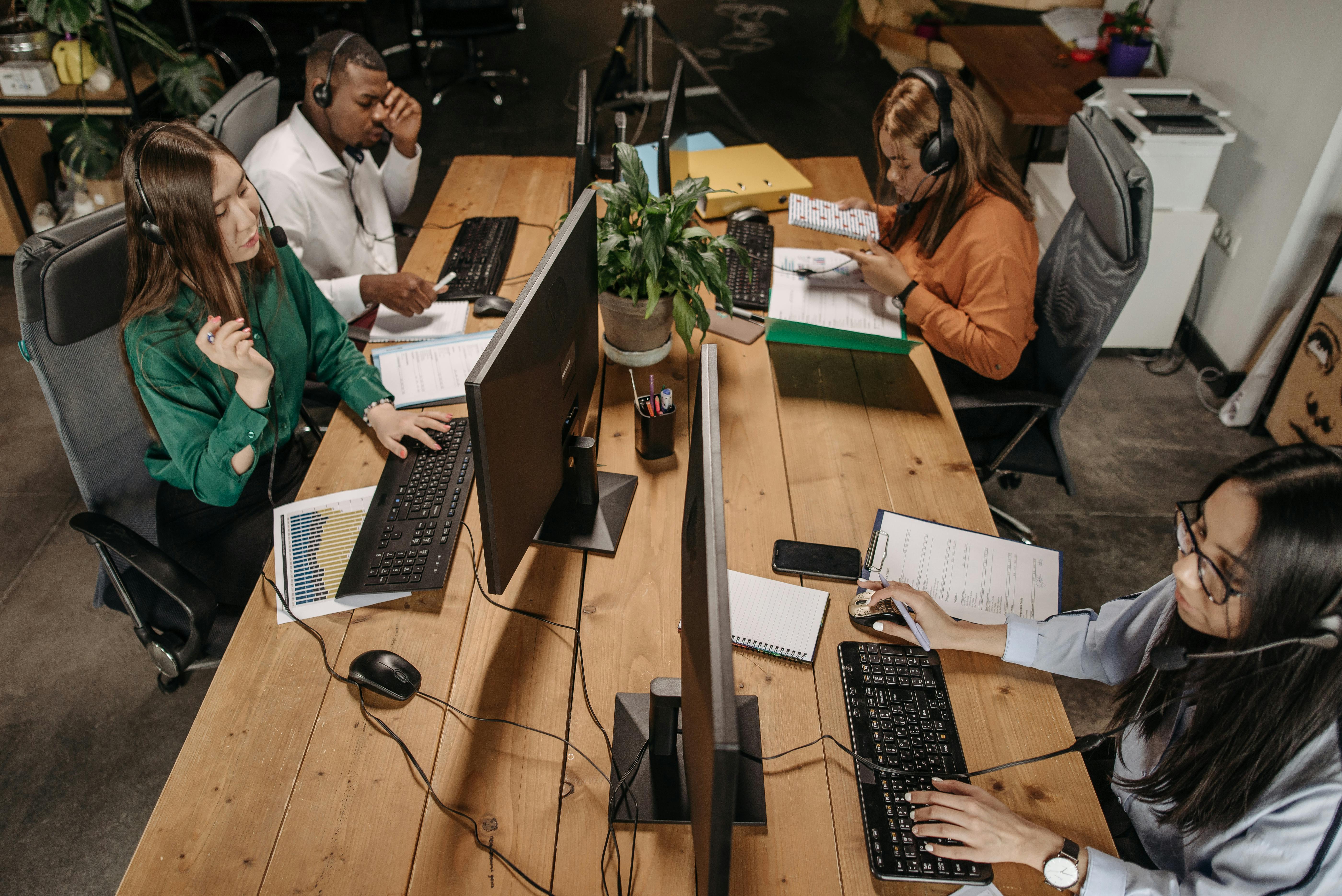 This is an image of contact centre agents working at a shared desk.