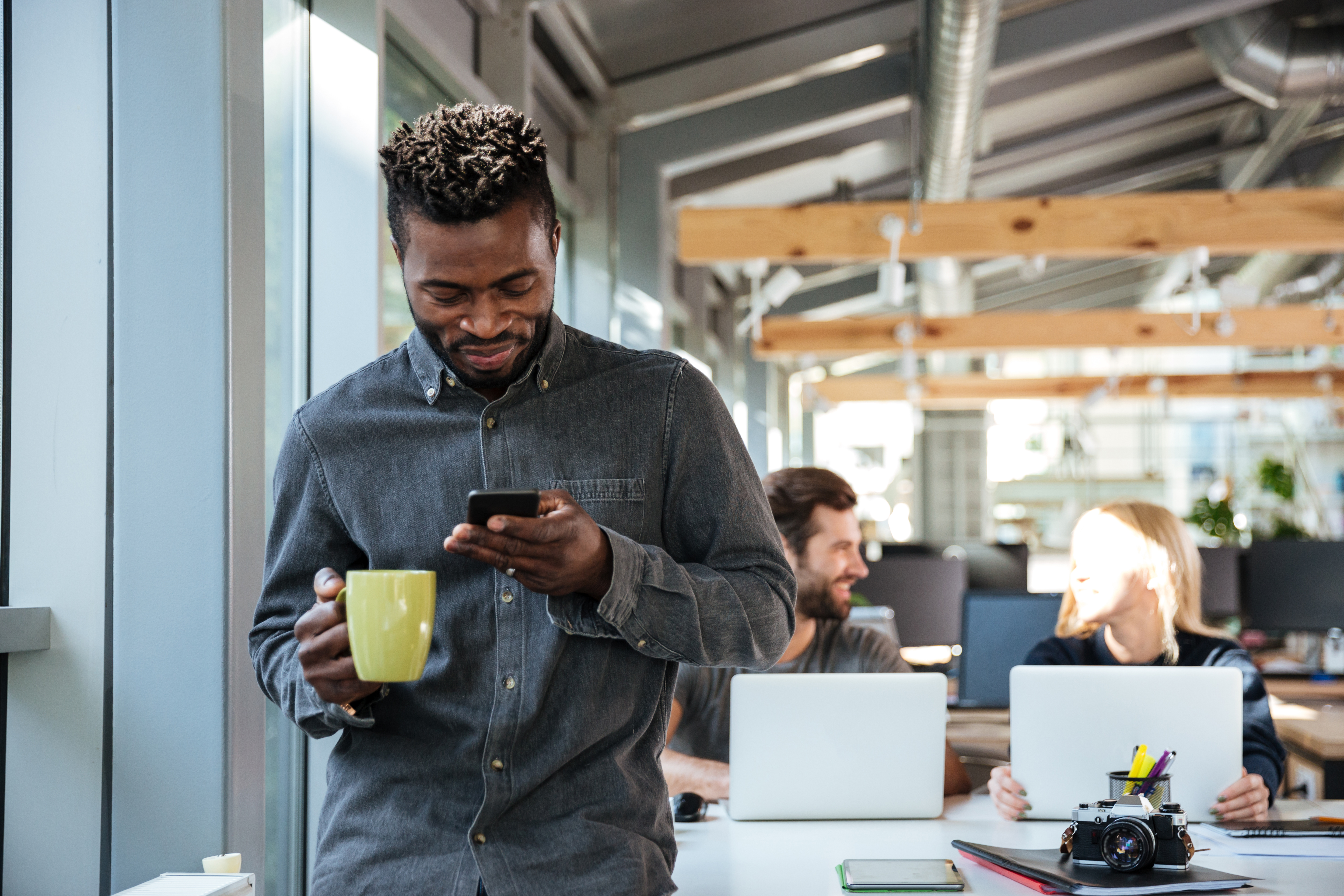 This is an image of a man on his phone while in an office.